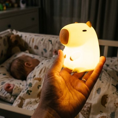 Veilleuse bébé en forme d’animal : une douce lumière tenue par la mère pour accompagner le sommeil de bébé.