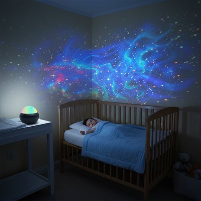 Le bébé dort dans sa chambre avec une veilleuse à projection sur le thème de l’espace.